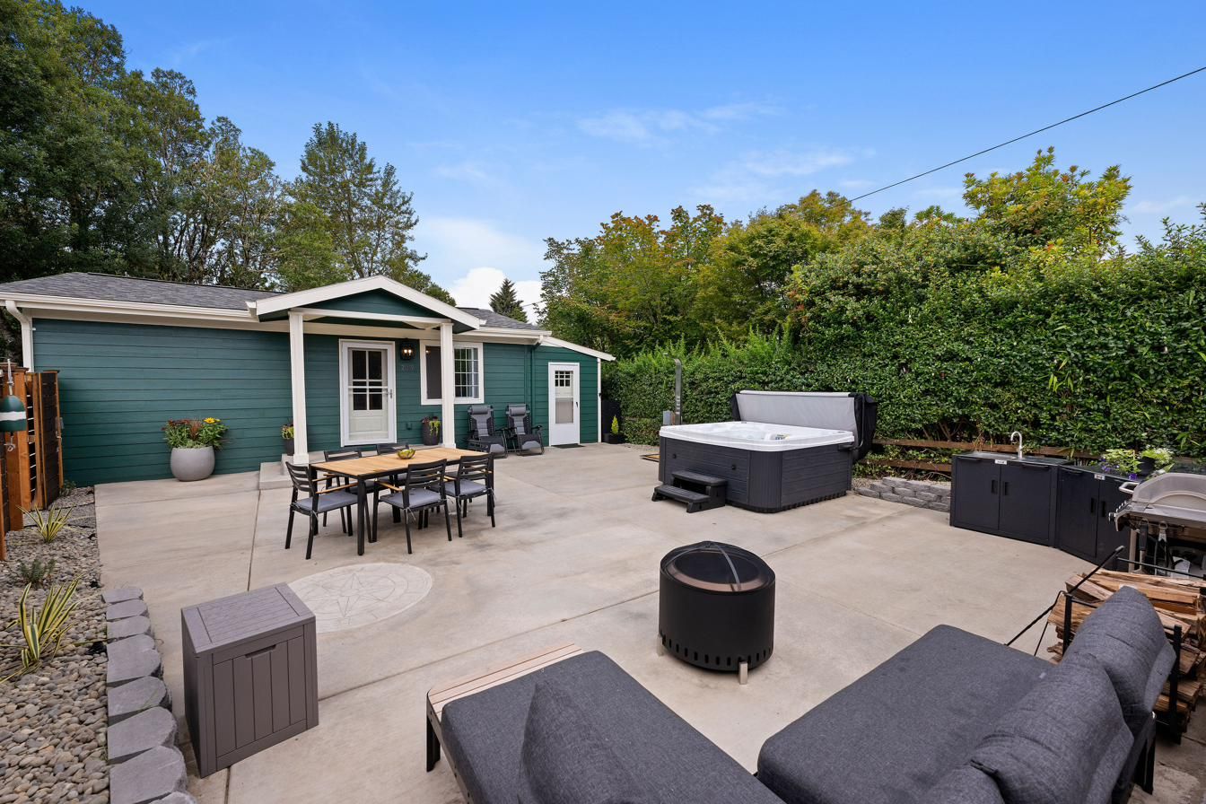 The courtyard: dining table, hot tub, outdoor kitchen and lounge