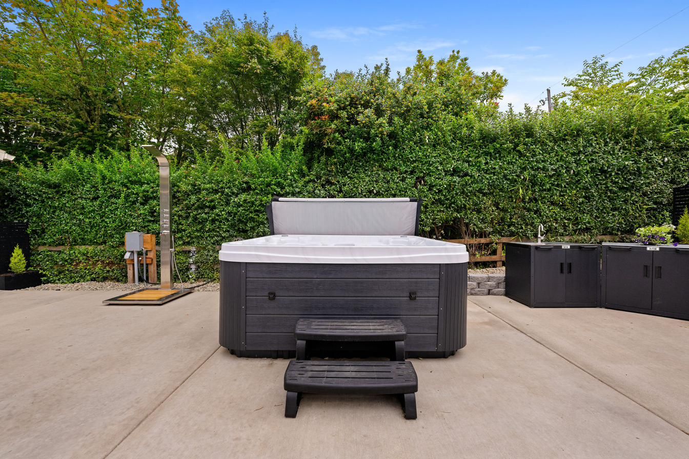 The hot tub and its steps against the hedge