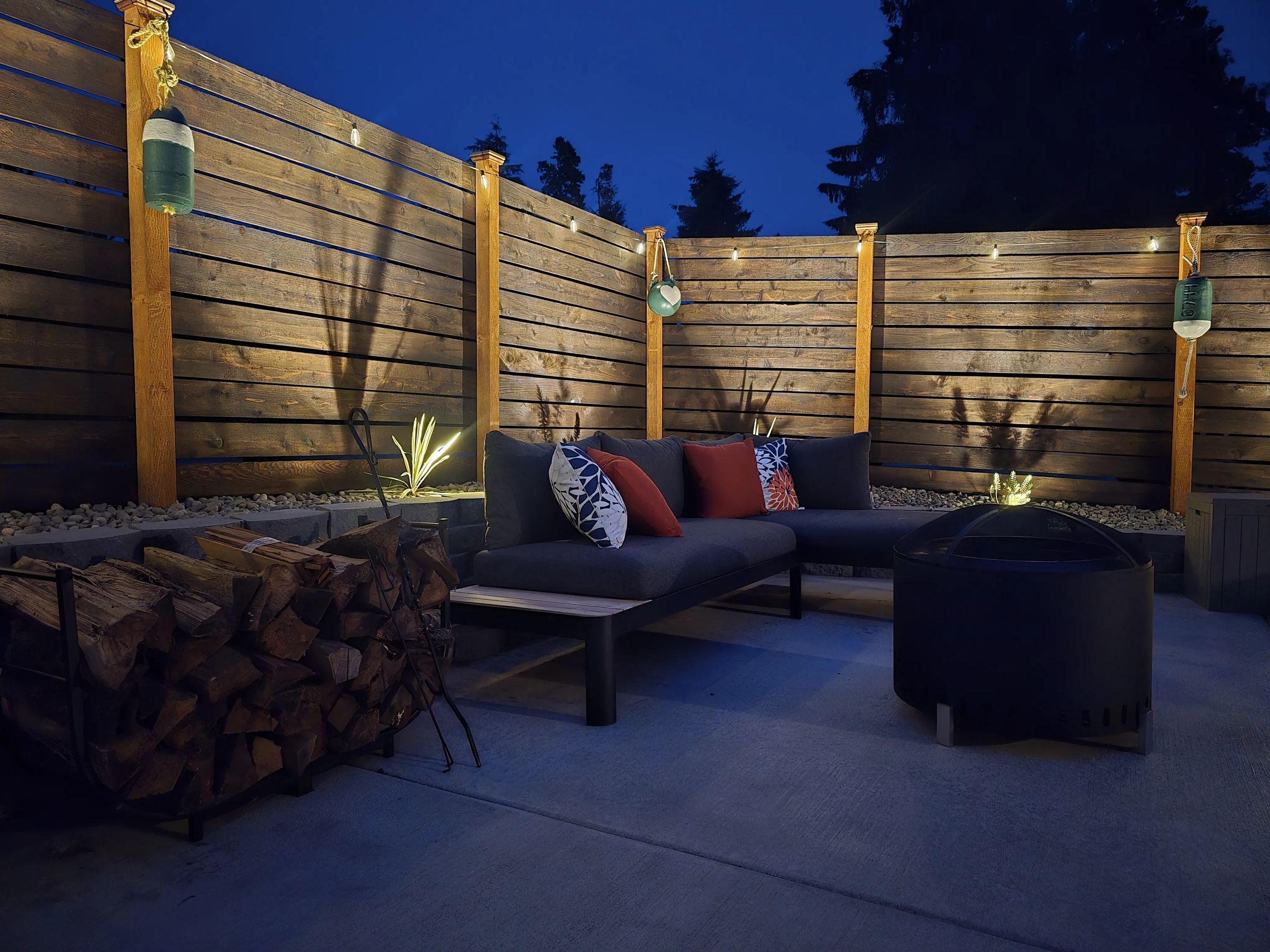 The fire pit lounge at night under string lights