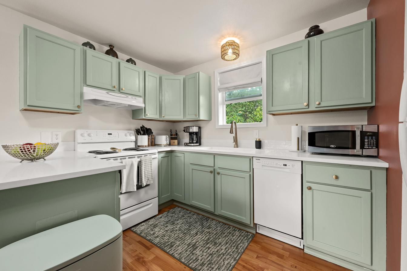 Kitchen with sage green cabinets and white counters
