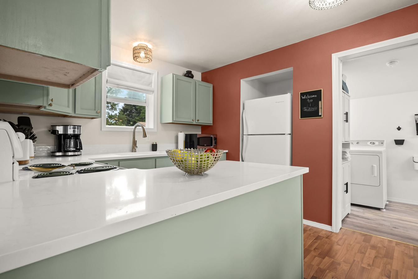 Kitchen counter with the refrigerator and mud room beyond