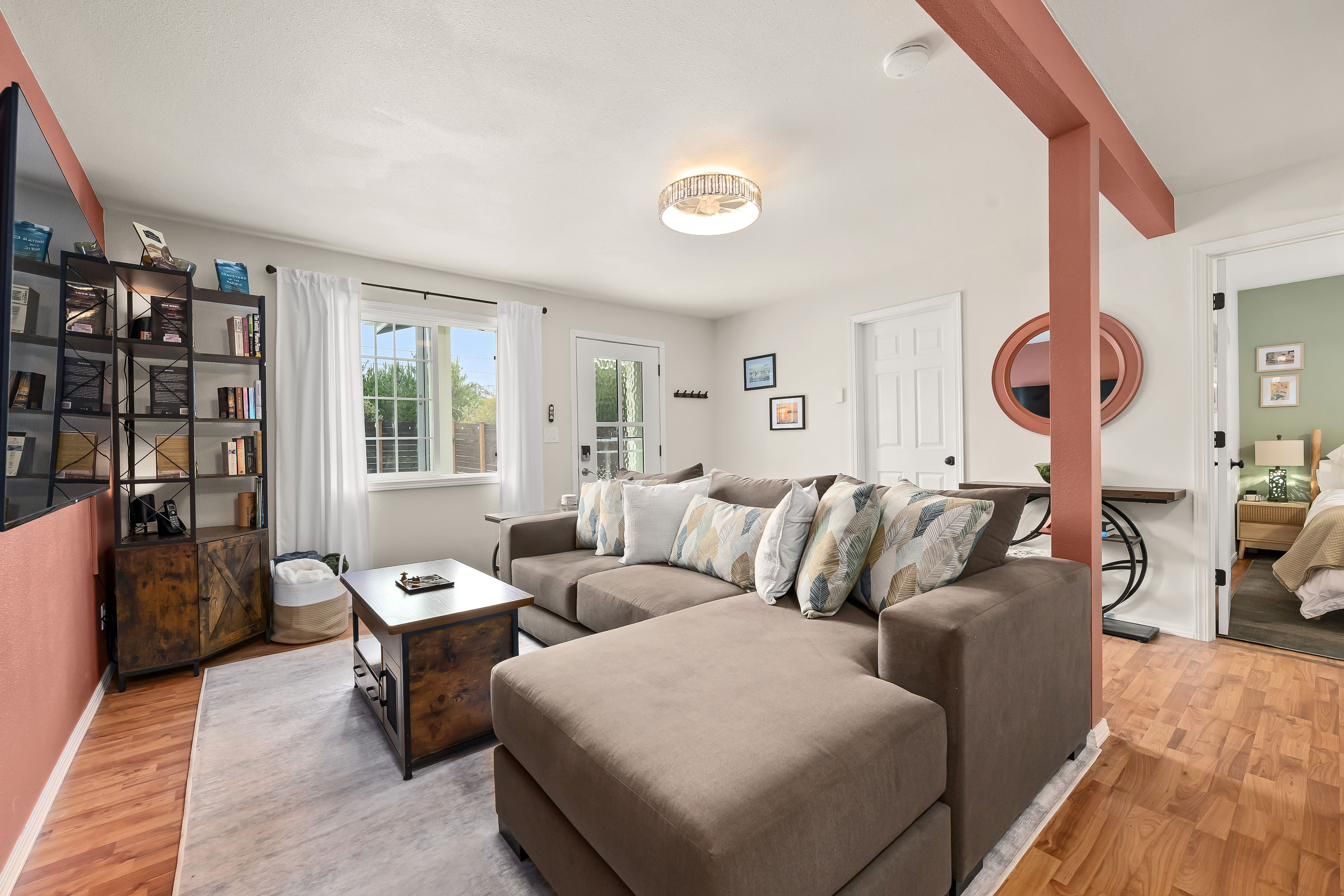 Living room from the entry, with sectional and bookshelves