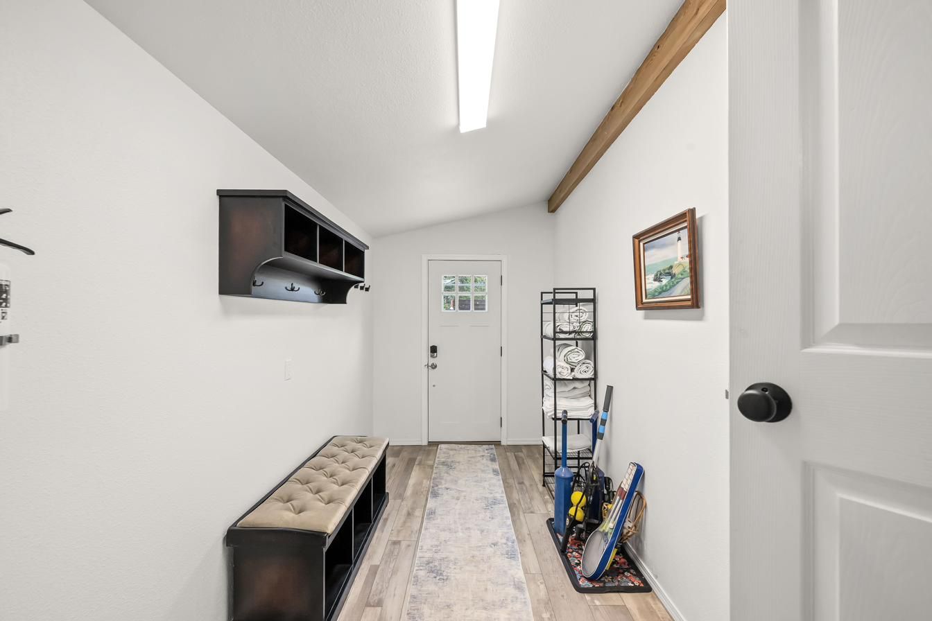 Mud room with bench, wall hooks and back door