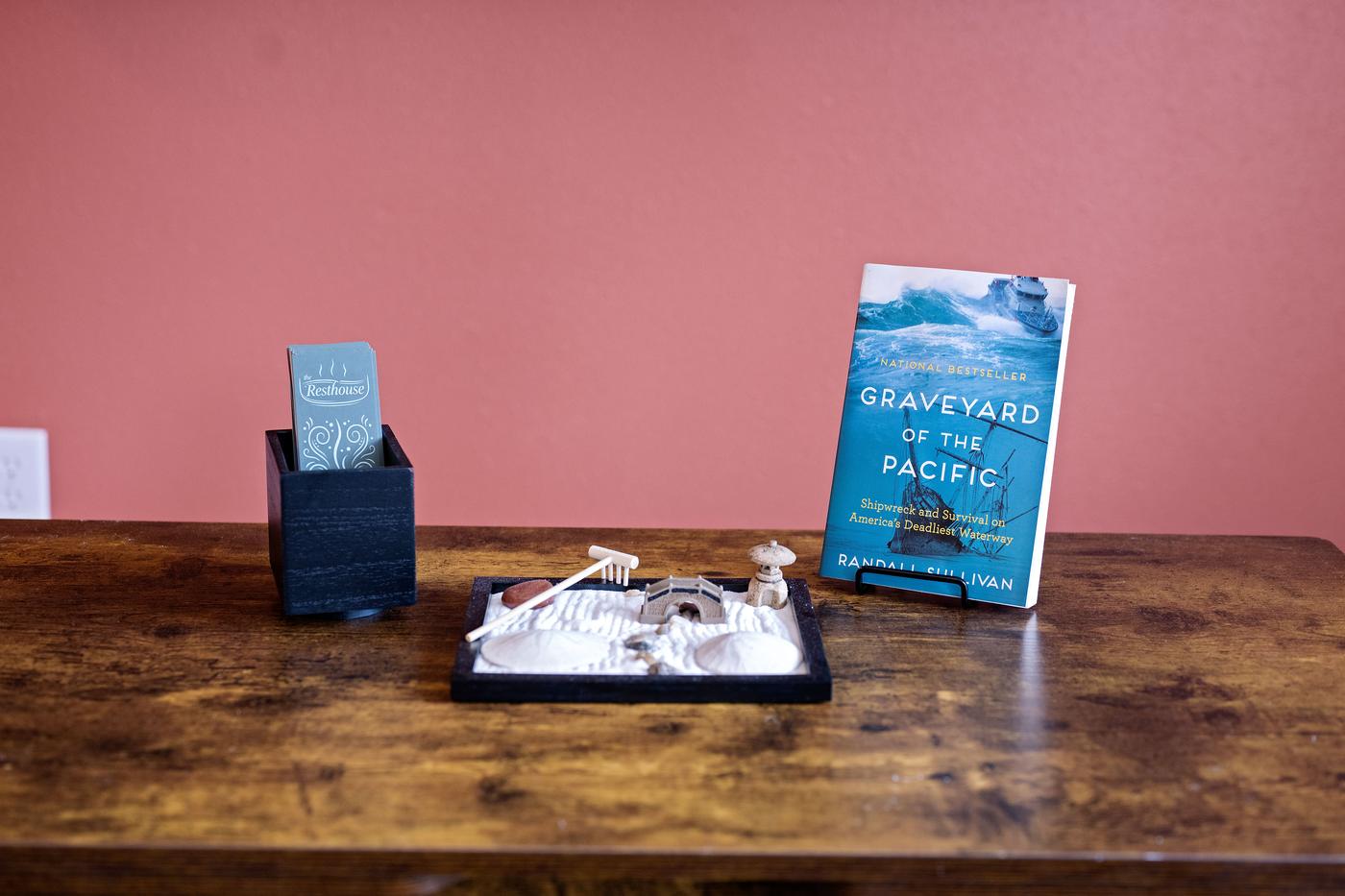 A Resthouse bookmark, a small zen garden and Graveyard of the Pacific on the living room table
