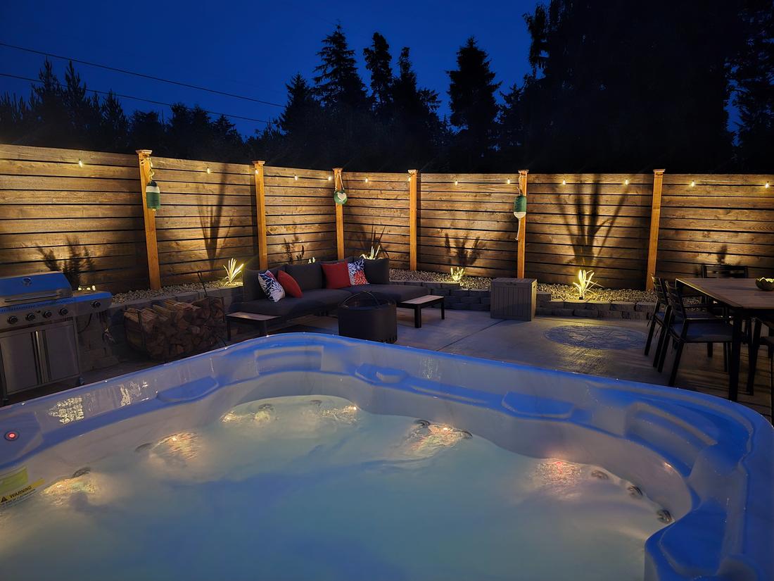 The courtyard at dusk, string lights along the cedar fence